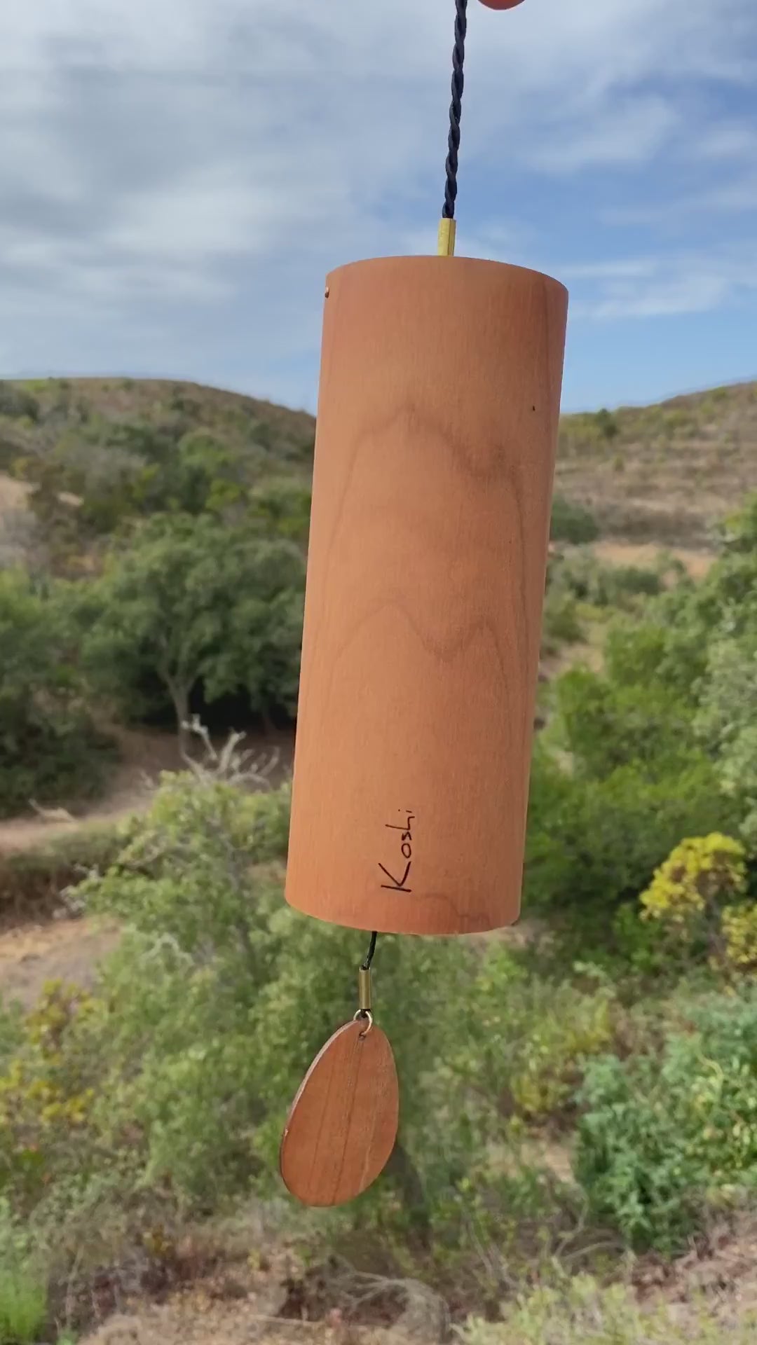 Koshi River chime in cherry wood against green hills, video with the original sound of the Earth Symphony collection